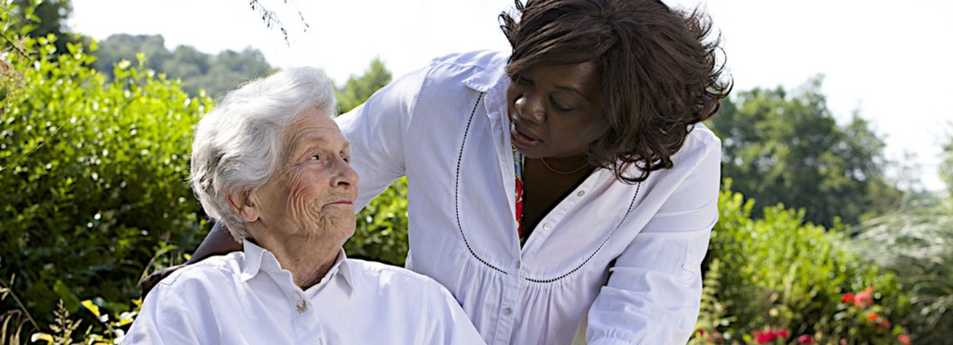 caregiver talking to disabled senior woman